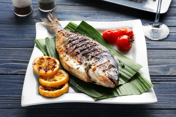 Plate with delicious fried fish on table