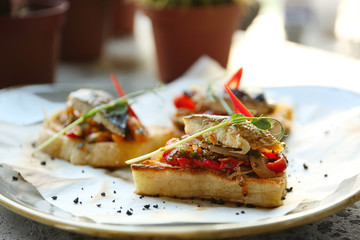 Delicious molletes with fillet of fish and vegetables on plate