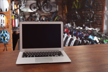 Counter with modern laptop in bicycle shop