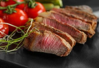 Sliced steak served with vegetables closeup