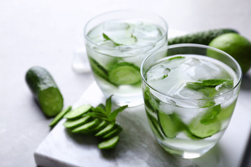Delicious refreshing water with mint and cucumber in glasses on table