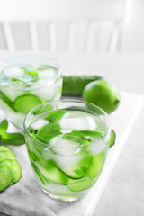 Delicious refreshing water with mint and cucumber in glass on marble board
