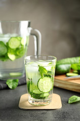 Delicious refreshing water with mint and cucumber in glass on table