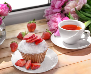 Delicious muffin and cup of tea on windowsill