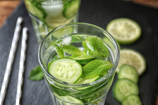 Delicious refreshing water with mint and cucumber in glass, closeup