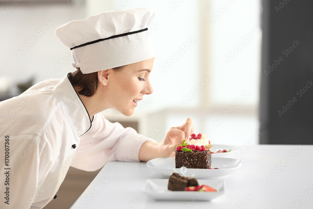 Sticker Female chef decorating tasty desserts in kitchen