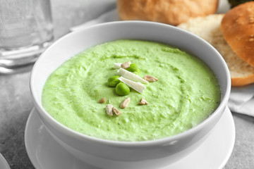Bowl with delicious broccoli soup on table