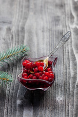 Cranberry sauce in glass on black rustic wooden background, soft focus