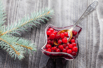 Cranberry sauce in glass on black rustic wooden background, soft focus