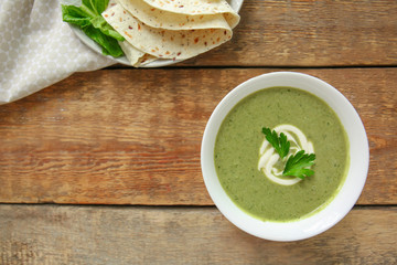 Bowl with fresh kale soup on table