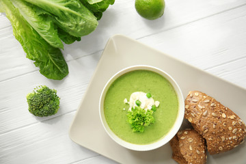 Bowl with fresh kale soup on table