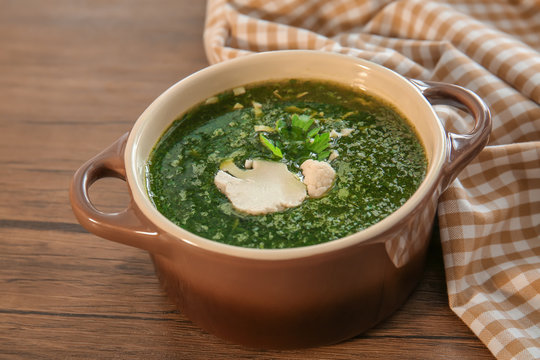 Casserole with fresh kale soup on table