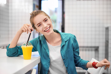 Young funny woman drinking smoothies indoors