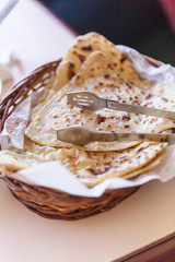 Grilled naan in the basket with tongs in dinning room of hotel in Darjeeling in winter, India.