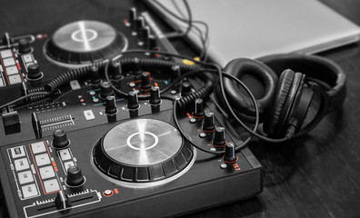 Fototapeta na wymiar DJ set with headphones and laptop on table