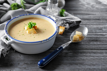 Obraz na płótnie Canvas Broccoli cheddar soup in casserole on wooden kitchen table