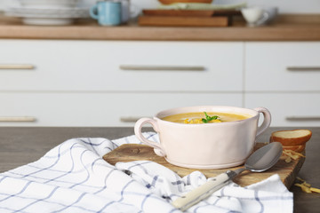 Broccoli cheddar soup in bowl on wooden board