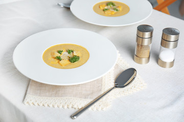 Plate with broccoli cheddar soup on kitchen table