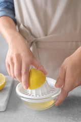 Man extracting lemon juice with plastic squeezer