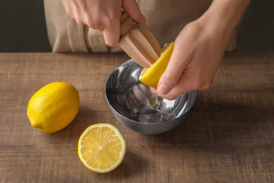 Man Extracting Lemon Juice With Wooden Citrus Reamer