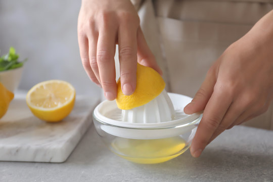 Man extracting lemon juice with plastic squeezer
