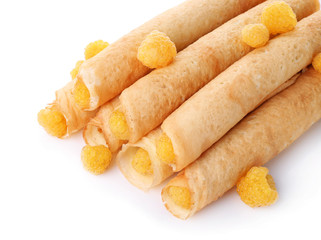 Rolled thin pancakes with yellow raspberry isolated on white