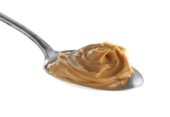 Creamy peanut butter in spoon on white background