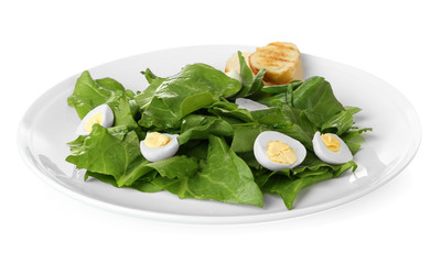Plate of salad with quail eggs and spinach isolated on white