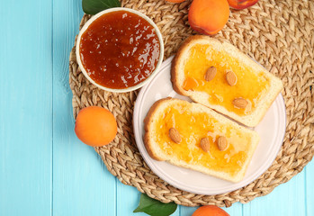 Two slices of bread with apricot jam on wicker mat