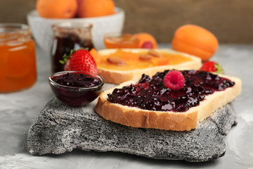 Slices of bread with tasty jams on table