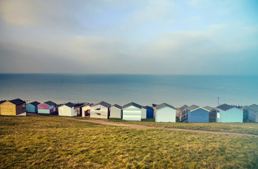 Blue sky and colorful beach huts along the coastline of Whitstable - retro styled photo