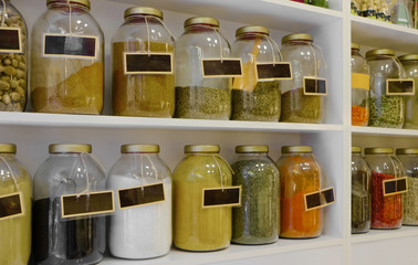 Different spices in jars on shelves