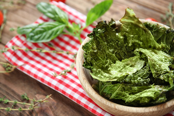 Bowl with lettuce chips on wooden table