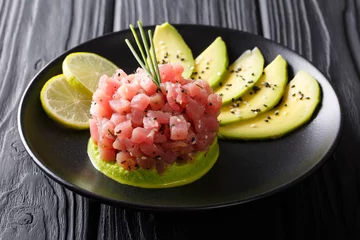 Rolgordijnen Beautiful food: fresh tuna tartar with lime, avocado and sesame close-up. horizontal © FomaA