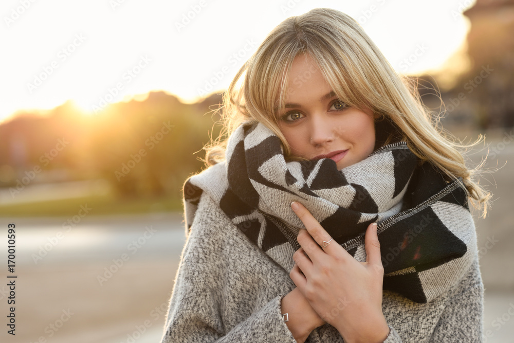 Wall mural beautiful young blonde woman in urban background