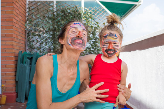portrait of mother and child with painted face looking
