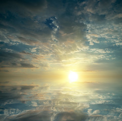 Naklejka na ściany i meble Dawn at sea, sun with rays and clouds.