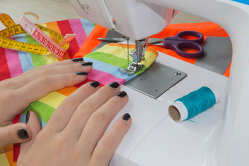 Woman's hands with dress at sewing machine