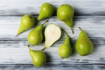 Top view of green pears over rustic wooden background