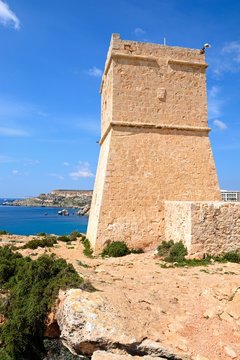 Ghajn Tuffieha watchtower overlooking the sea and cliffs, Golden Bay, Malta.