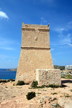 Ghajn Tuffieha watchtower overlooking the sea and cliffs, Golden Bay, Malta.