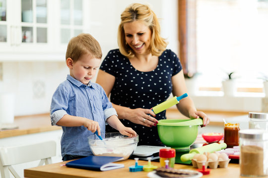 Child helping mother bake cookies