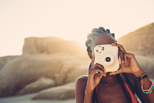 African american female taking pictures on the beach