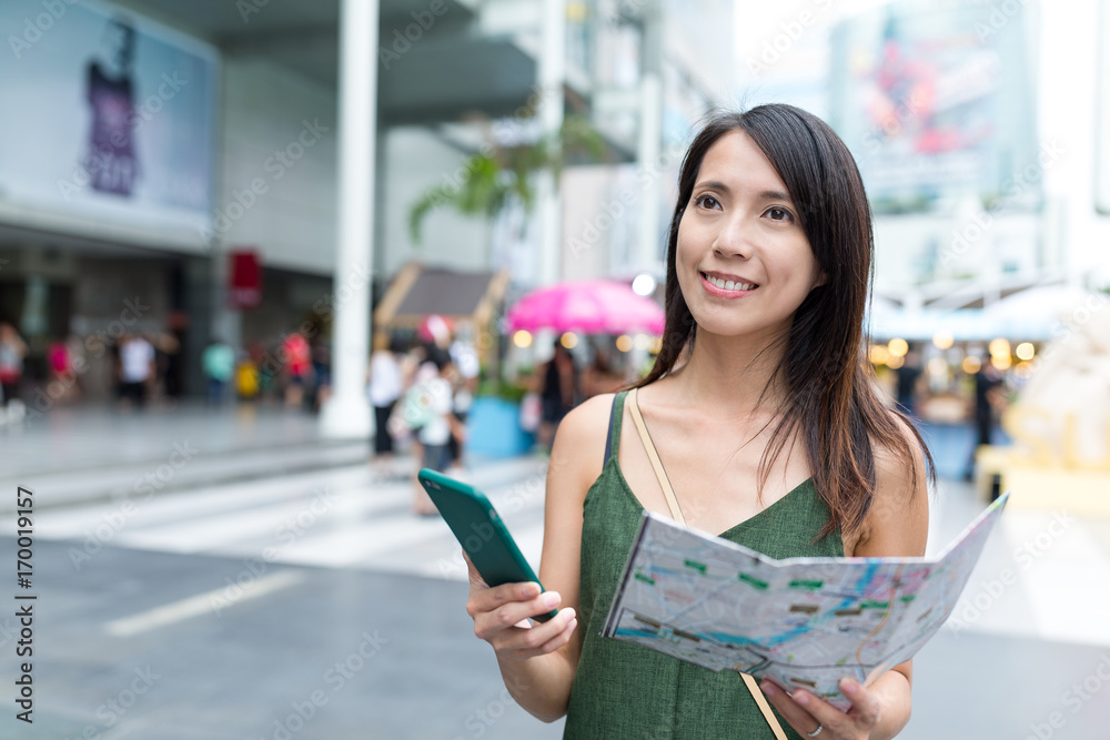 Wall mural Tourist using cellphone and holding city map in Bangkok