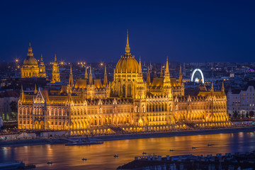 Fototapeta na wymiar Budapest, Hungary - Panoramic skyline view of the beautiful illuminated Parliament of Hungary and St Stephens Basilica at blue hour