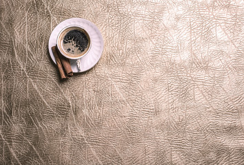 cup with coffee on a leather table, top view