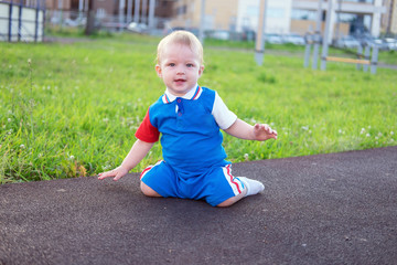 A little boy is sitting on the ground