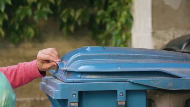 Young man in red sportswear throwing away rubbish. Close-up shot
