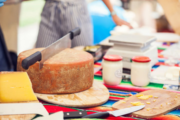 a person cut a cheese in the cheese market.