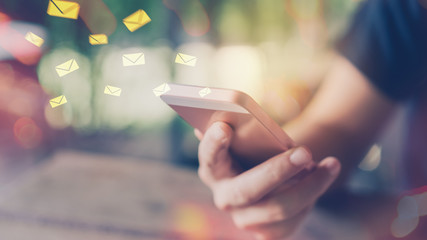 Woman hand using smart phone double exposure email fly draw bokeh at cafe.